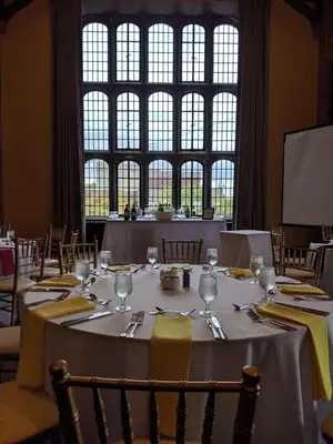 a dining room with a table with plates and wine glasses at The Tudor Arms Hotel Cleveland - a DoubleTree by Hilton in Cleveland