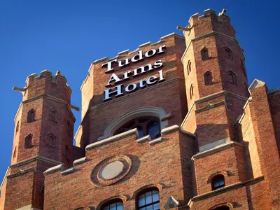 a brick building with two towers on top of it at The Tudor Arms Hotel Cleveland - a DoubleTree by Hilton in Cleveland