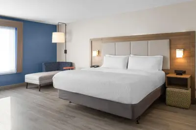 a bedroom with a large bed and a chair at Holiday Inn Express & Suites Mt Sterling North by IHG in Mount Sterling