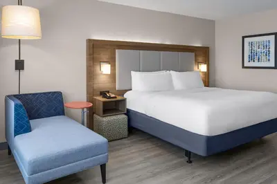 a bed and a chair in a hotel room at Holiday Inn Express & Suites Mt Sterling North by IHG in Mount Sterling