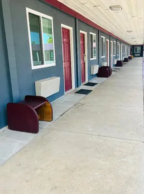 a row of benches in a building with red doors at Highlander Motel in Athens