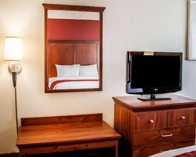 a bedroom with a tv on a dresser with a bed at Quality Inn Lima Northeast in Lima