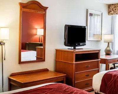 a hotel room with a bed and a tv on a dresser at Quality Inn Lima Northeast in Lima