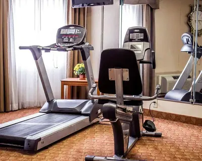 a gym with a treadmill and a chair in a room at Quality Inn Lima Northeast in Lima