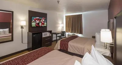 a hotel room with two beds and a flat screen tv at Red Roof Inn Columbus - Hebron in Hebron
