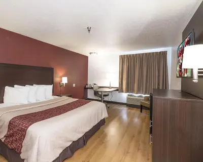 a hotel room with a large bed and a desk at Red Roof Inn Columbus - Hebron in Hebron