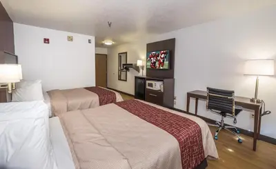a hotel room with two beds and a desk at Red Roof Inn Columbus - Hebron in Hebron