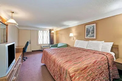 a hotel room with a bed and a flat screen tv at Knights Inn Charleston West Virginia in Charleston