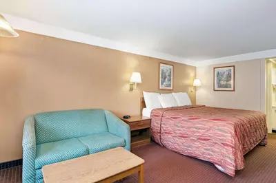 a hotel room with a bed and a chair at Knights Inn Charleston West Virginia in Charleston