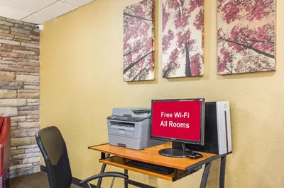 a desk with a computer and a sign that says free wifi air fronts at Red Roof Inn Cincinnati Airport–Florence/ Erlanger in Erlanger