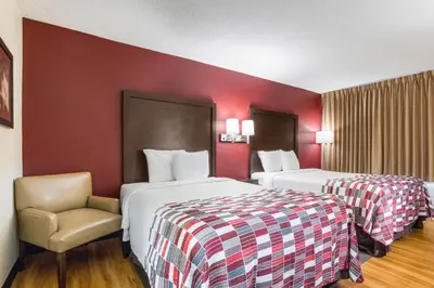 a hotel room with two beds and a chair at Red Roof Inn Cincinnati Airport–Florence/ Erlanger in Erlanger