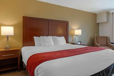 a hotel room with a large bed and a chair at Comfort Inn Pickerington - Columbus East in Pickerington
