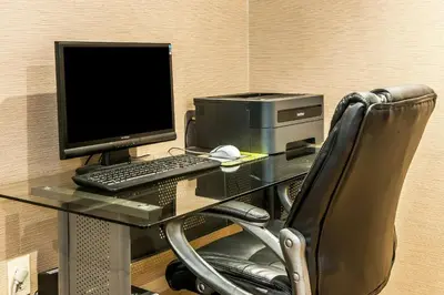 a desk with a computer and a monitor and a chair at Comfort Inn Pickerington - Columbus East in Pickerington