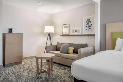 a hotel room with a bed and a couch at Country Inn & Suites by Radisson, Dayton South, OH in Dayton