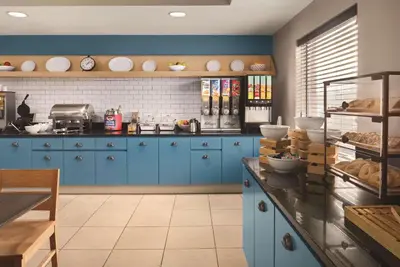 a kitchen with blue cabinets and a counter with food at Country Inn & Suites by Radisson, Dayton South, OH in Dayton