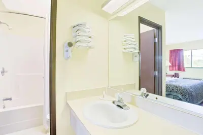 a white bathroom with a sink and a mirror at Days Inn by Wyndham Athens in Athens