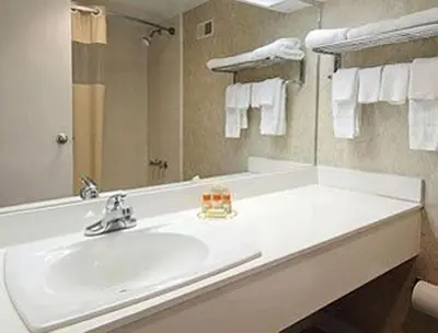 a bathroom with a white sink and a mirror at Days Inn by Wyndham Athens in Athens