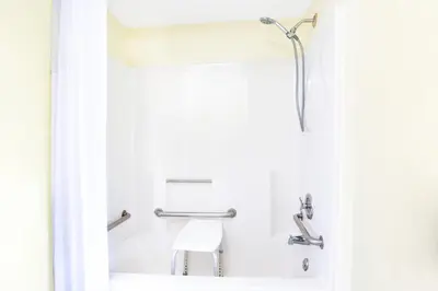 a shower in a bathroom with a chair at Days Inn by Wyndham Athens in Athens