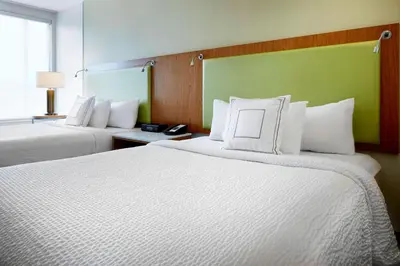 a hotel room with two beds with white pillows at SpringHill Suites by Marriott Columbus OSU in Columbus