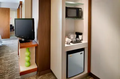a hotel room with a tv and a kitchen with a stove at SpringHill Suites by Marriott Columbus OSU in Columbus