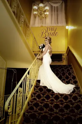 a bride walking down a staircase in her wedding dress at Lafayette Hotel Marietta in Marietta
