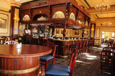 a bar in a restaurant with tables and chairs at Lafayette Hotel Marietta in Marietta