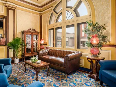 a living room with a leather couch and a large window at Lafayette Hotel Marietta in Marietta