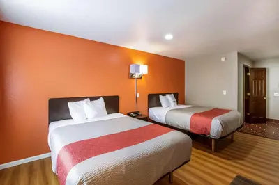 two beds in a hotel room with orange walls at Motel 6-Rossford, OH in Rossford