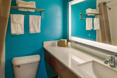 a bathroom with a toilet and a sink and a mirror at Motel 6-Rossford, OH in Rossford