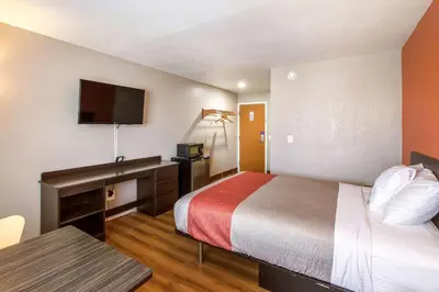 a hotel room with a bed and a desk and a tv at Motel 6-Rossford, OH in Rossford