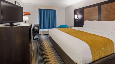 a hotel room with a large bed and a flat screen tv at SureStay Hotel by Best Western Florence in Florence