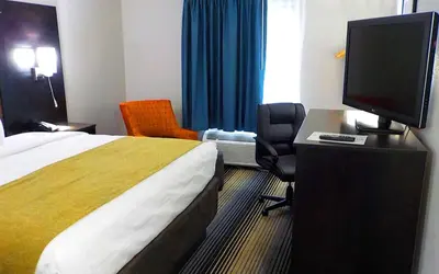a hotel room with a bed and a flat screen tv at SureStay Hotel by Best Western Florence in Florence