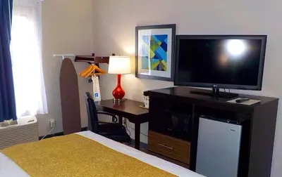 a bedroom with a desk with a television and a bed at SureStay Hotel by Best Western Florence in Florence
