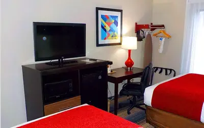 a hotel room with a bed and a desk with a television at SureStay Hotel by Best Western Florence in Florence