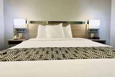 a bed in a hotel room with two lamps on both sides at Microtel Inn Georgetown - Lexington North in Georgetown