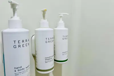 a group of four white shampoo bottles sitting on a shelf at Microtel Inn Georgetown - Lexington North in Georgetown