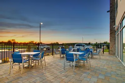 a patio with tables and chairs and a fence at Holiday Inn Express & Suites Findlay North by IHG in Findlay