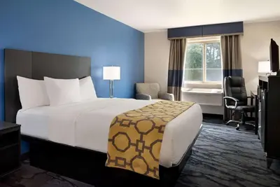 a hotel room with a large bed and a window at Baymont Toledo Airport Hotel Swanton in Swanton