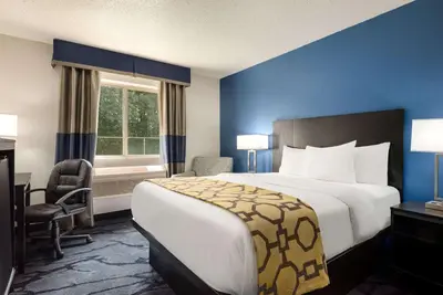 a hotel room with a large bed and a window at Baymont Toledo Airport Hotel Swanton in Swanton