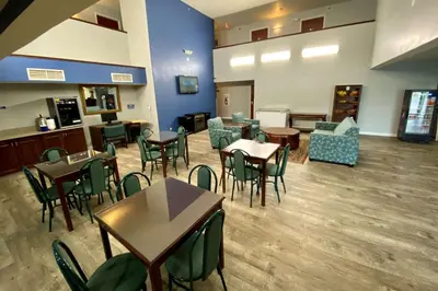 a waiting room with tables and chairs in a hospital at Baymont Toledo Airport Hotel Swanton in Swanton