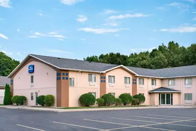 a hotel with a parking lot in front of it at Baymont Toledo Airport Hotel Swanton in Swanton