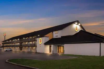 a large white building with a parking lot at Super 8 by Wyndham Vandalia/Dayton International Airport in Vandalia