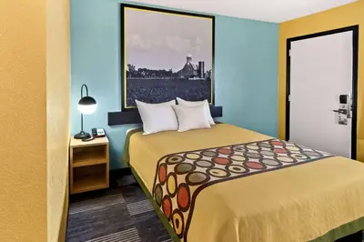a hotel room with a bed and a picture on the wall at Super 8 by Wyndham Vandalia/Dayton International Airport in Vandalia