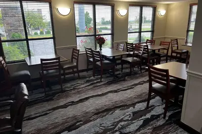 a dining room with tables and chairs and windows at Baymont By Wyndham Monroe Ohio in Monroe