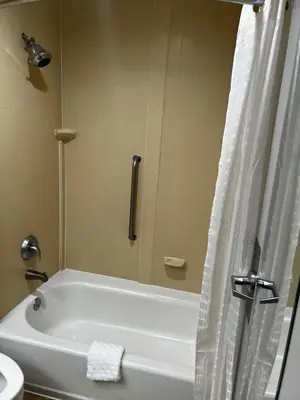 a white bath tub in a bathroom with a shower at Baymont By Wyndham Monroe Ohio in Monroe