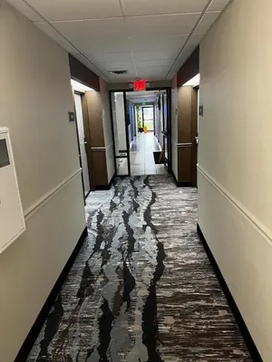 a hallway of an office building with water on the floor at Baymont By Wyndham Monroe Ohio in Monroe