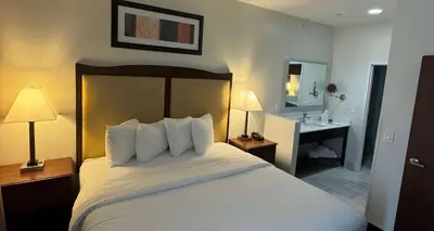 a hotel room with a large bed and a bathroom at Best Western PLUS Hannaford Inn & Suites in Cincinnati