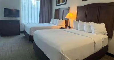 a hotel room with two beds and a television at Best Western PLUS Hannaford Inn & Suites in Cincinnati