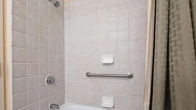 a bathroom with a shower with a tub and a toilet at Best Western PLUS Hannaford Inn & Suites in Cincinnati