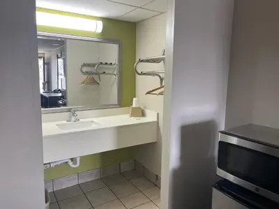 a bathroom with a sink and a mirror and a tv at Blue Stone Inn in Washington Court House